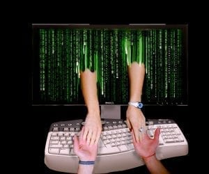 Online romance &ndash; man and woman joining hands through computer monitor; image by Don Hankins, via Flickr, CC BY 2.0, no changes.