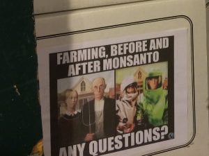 Flyer saying &ldquo;Farming, before and after Monsanto. Any questions?&rdquo; with Grant Wood&rsquo;s American Gothic on the left and a modified version with the couple wearing hazmat suits on the right. Image by Kevin Krejci, via Flickr, CC BY 2.0, no changes.