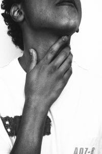 Person with hand on neck, right ear to camera; image by Jo&atilde;o Silas, via Unsplash.com.