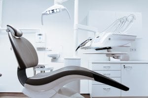 Dentist&rsquo;s chair in exam room; image by Daniel Frank, via Unsplash.com.