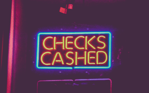 Neon &ldquo;Checks cashed&rdquo; sign; image by Tony Webster from Oakland, California, CC BY 2.0, no changes.