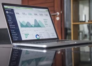 Laptop with financial software running onscreen; image by Carlos Muza, via Unsplash.com.