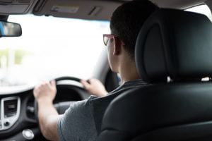 Man driving car during daytime; image by Art Markiv, via Unsplash.com.