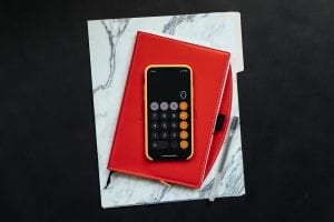 Black Android smartphone on red flip case; image by Kelly Skiiema, via Unsplash.com.