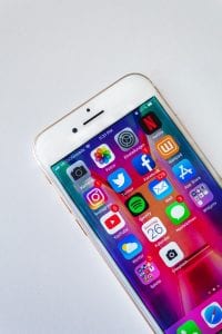 Smartphone with various icons on the screen; image by Sara Kurfe&szlig;, via Unsplash.com.