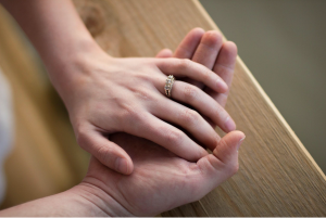 Man and woman wearing wedding ring holding hands; image by Rachel Crowe, via Unsplash.com.