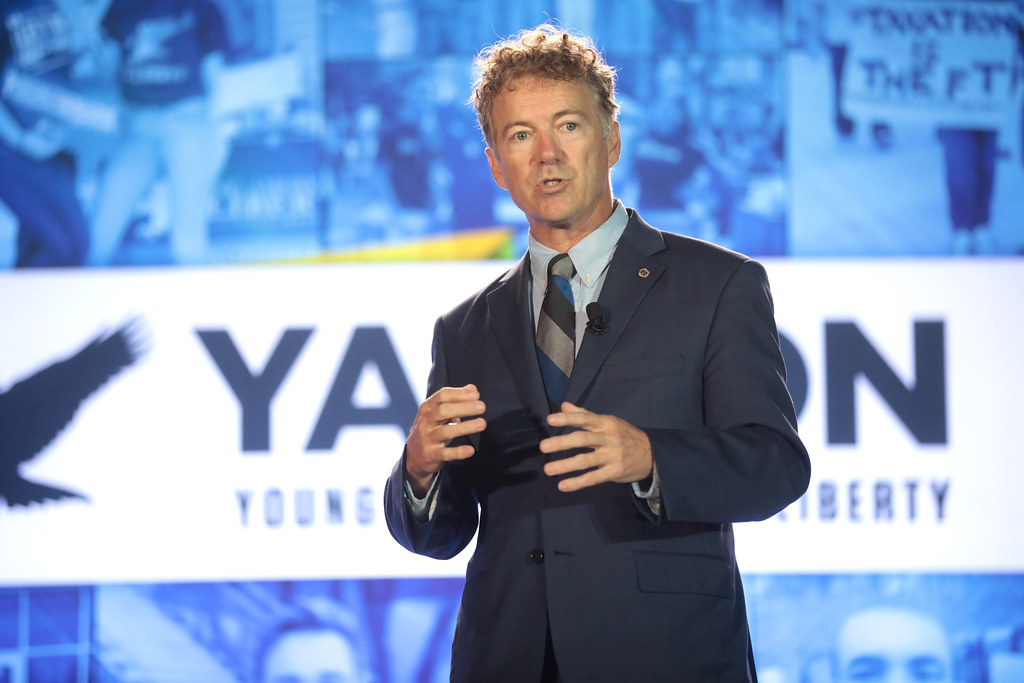 A man in a suit gesturing with his hands.