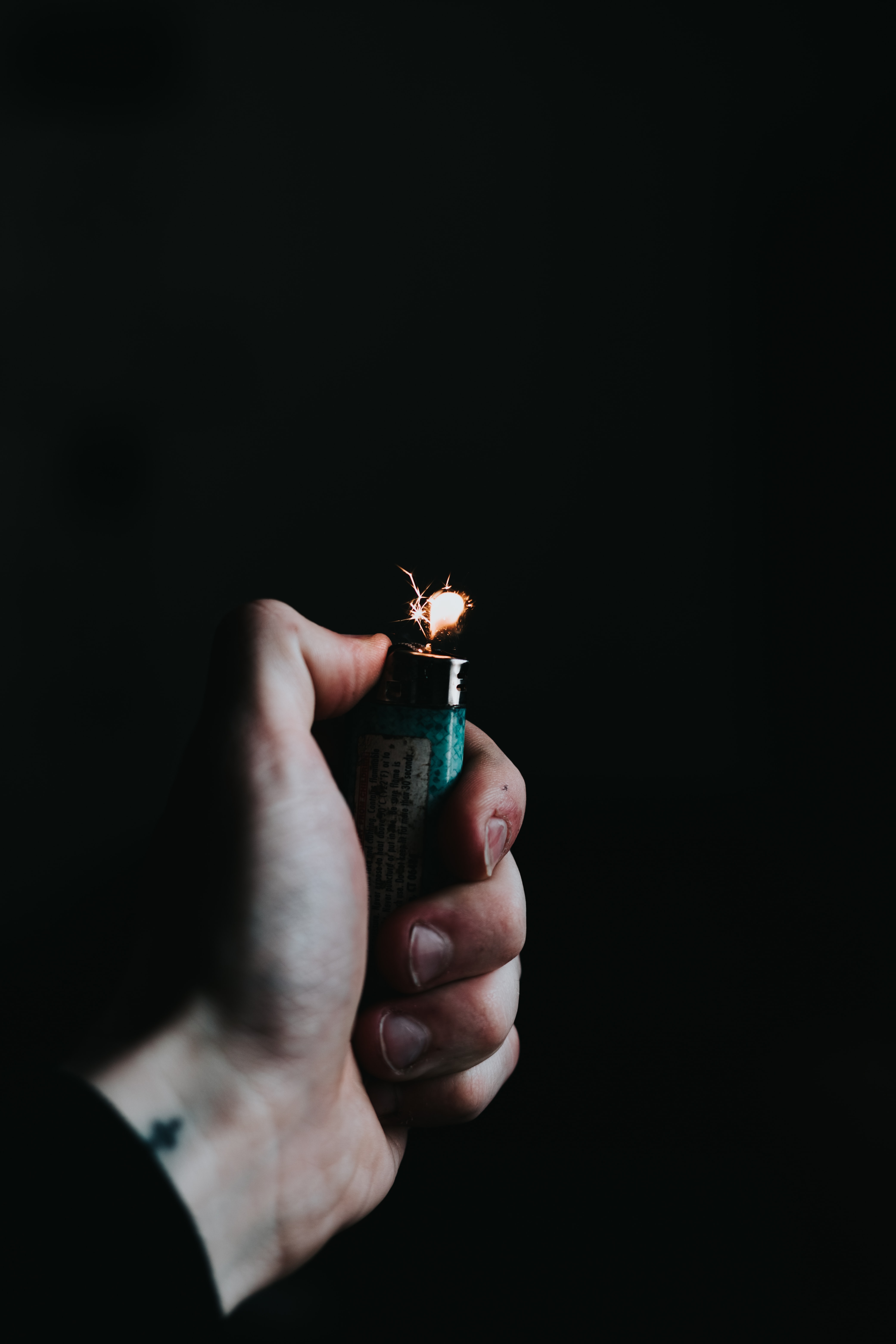 Man with lighter; image by Devin Avery, via Unsplash.com.