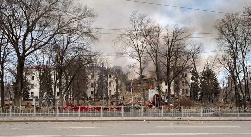 A panoramic view of a building with a crater exploded out of it.