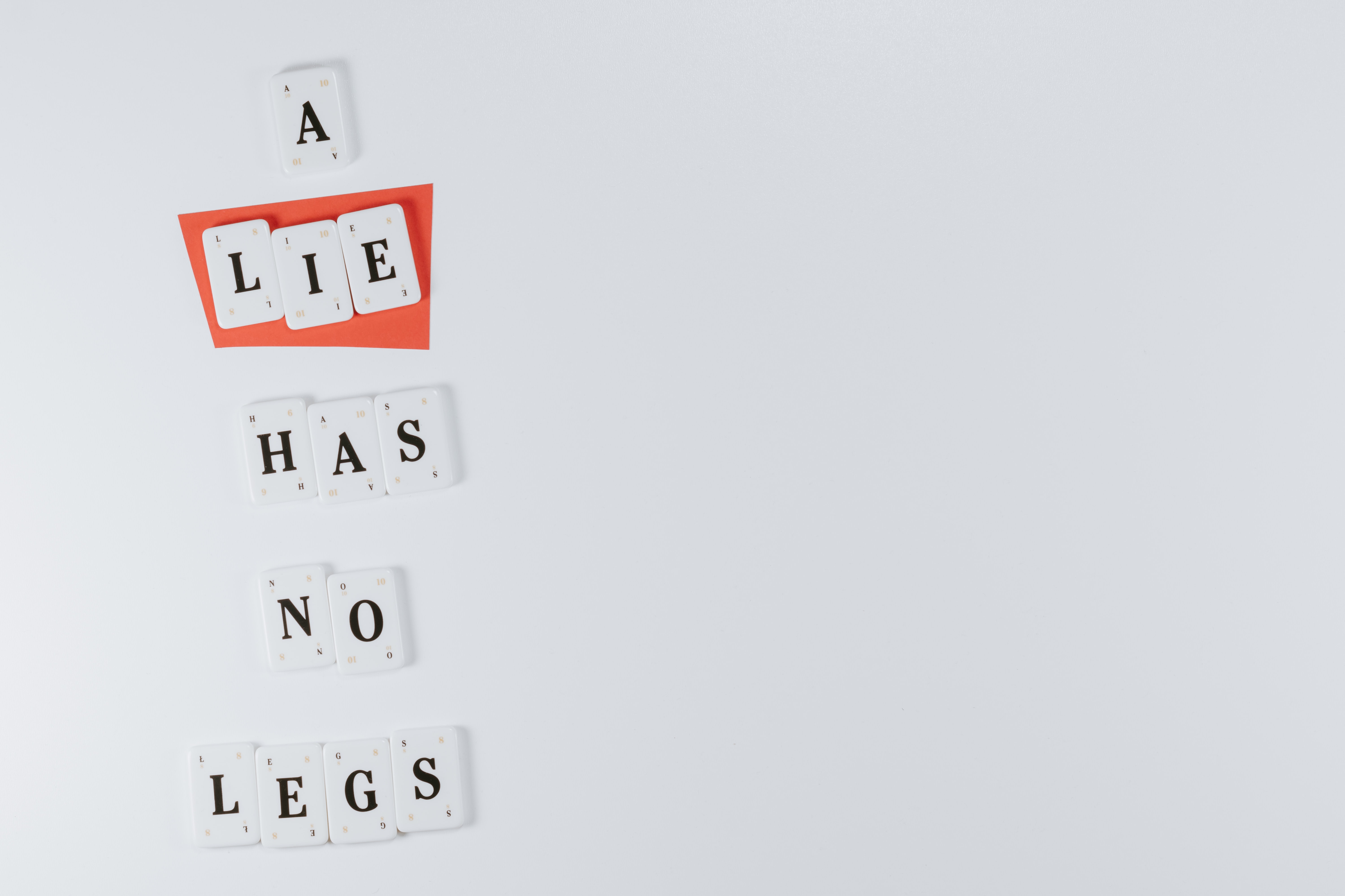White tiles spelling out A Lie Has No Legs; image by Pawel Czerwinski, via Unsplash.com.
