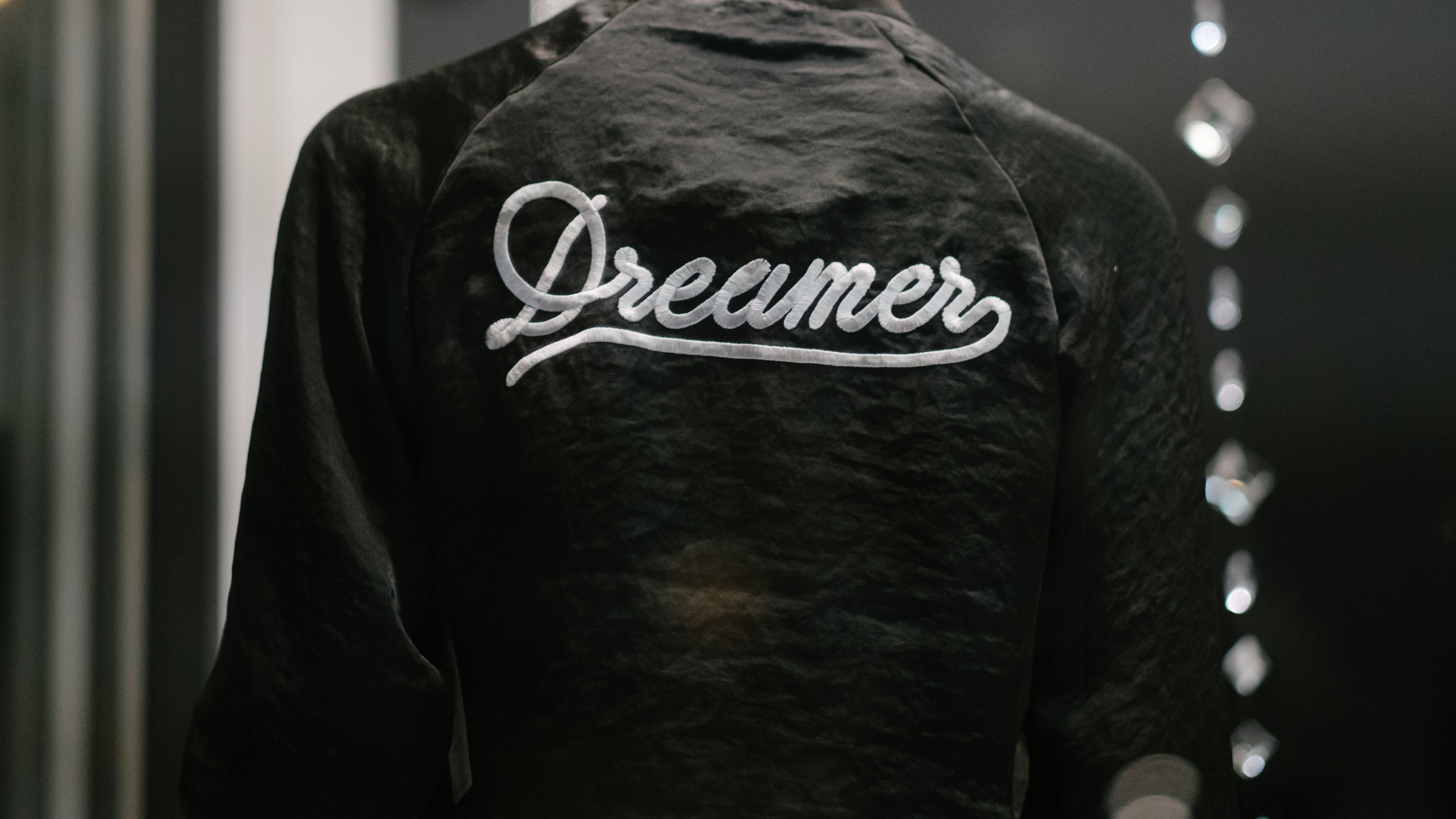 Black jacket with Dreamer embroidered in white; image by Rob Walsh, via Unsplash.com.