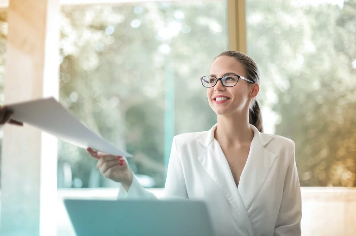 Businesswoman handling paperwork; image by Andrea Piacquadio, via Pexels.com.