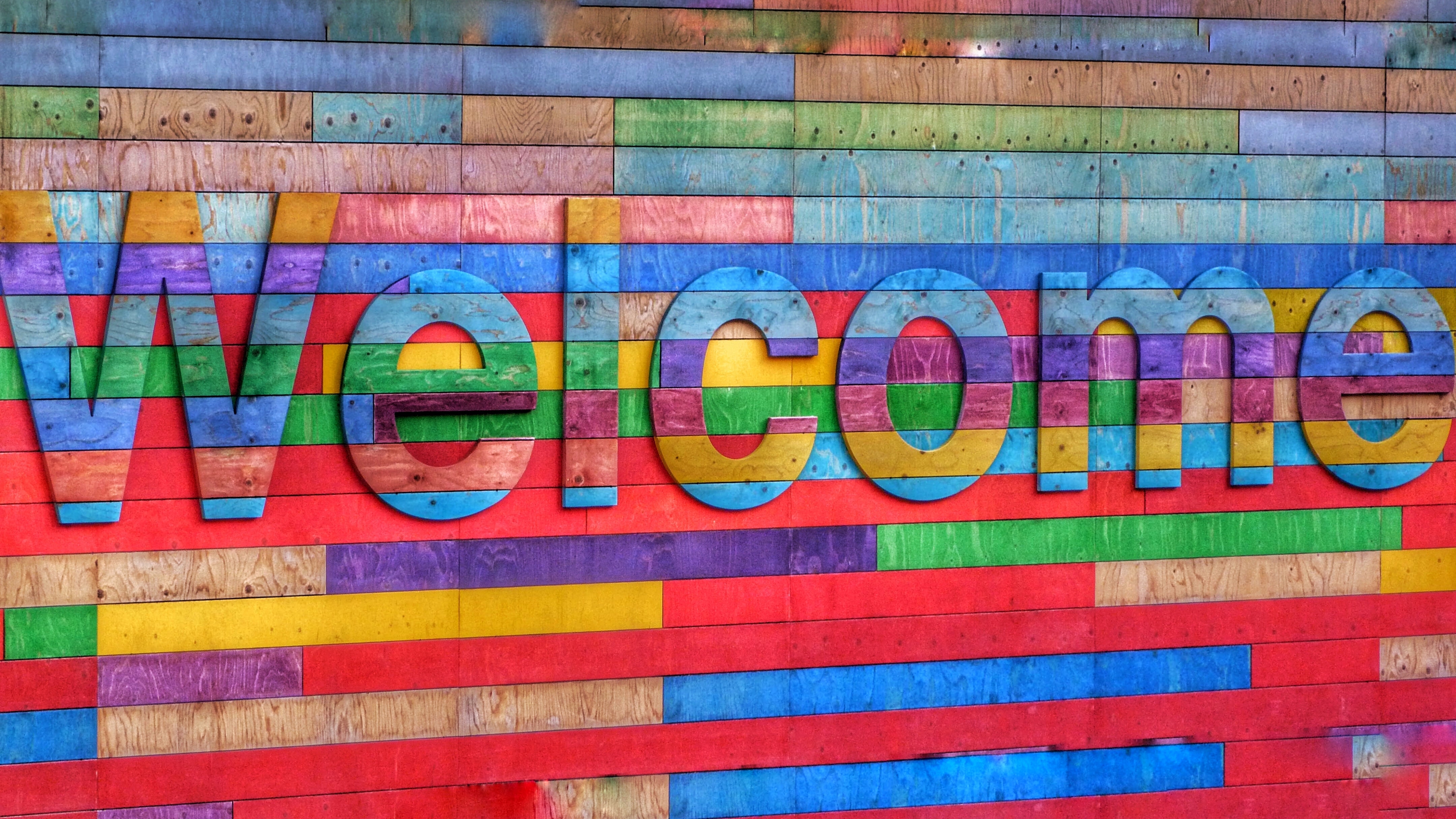 Multicolored Welcome sigh; image by Belinda Fewings, via Unsplash.com.