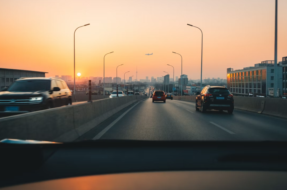Highway traffic at sunrise; image by Xiaolong Wong, via Unsplash.com.