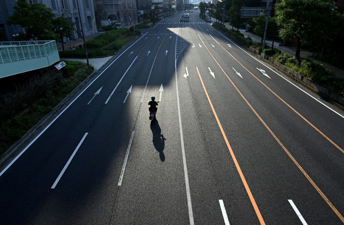 Motorcycle going down empty road; image by Yamabon, via Pixabay.com.