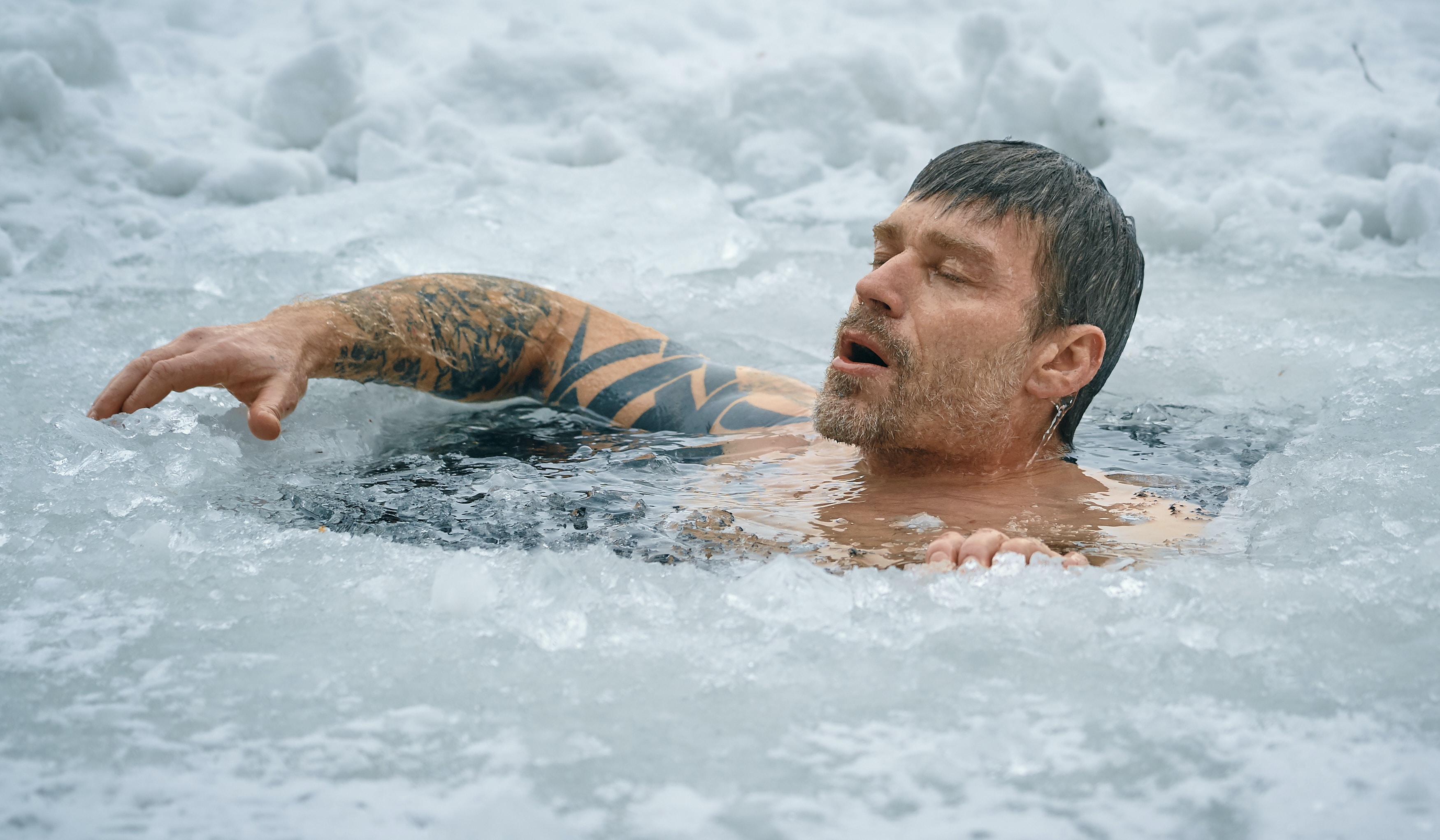 Man doing ice plunge in lake; image by Vidar Nordli Mathisen, via Unsplash.com.