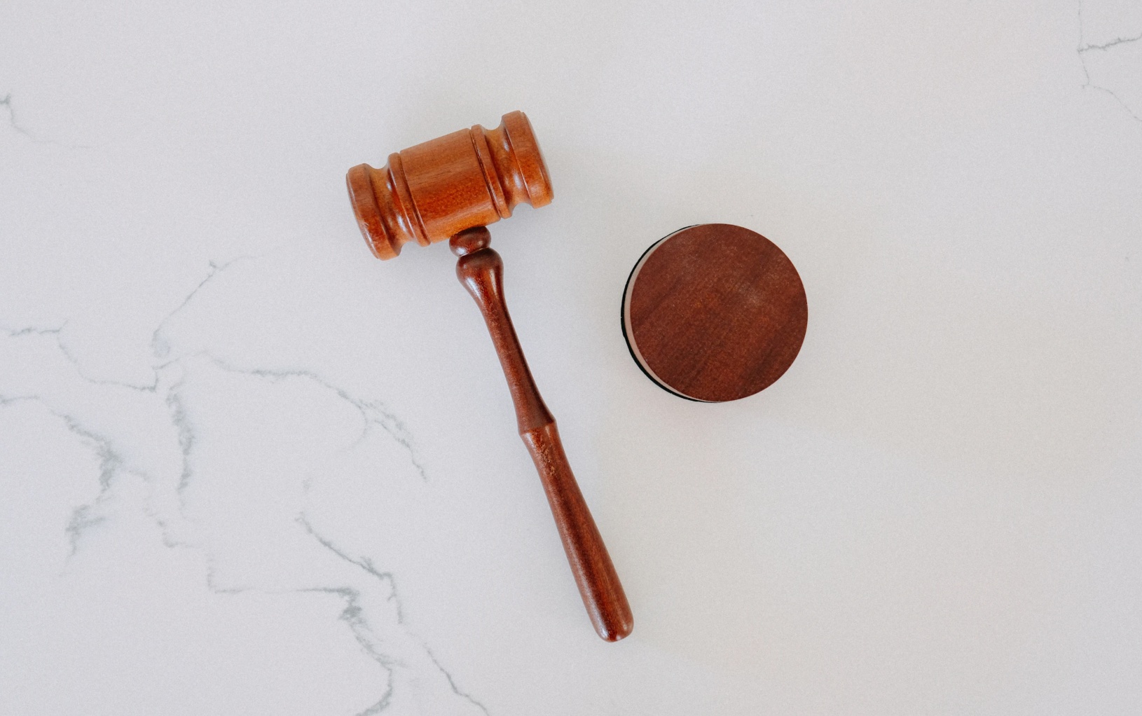 Gavel on white marbled background; image by Tingey Injury Law Firm, via Unsplash.com.