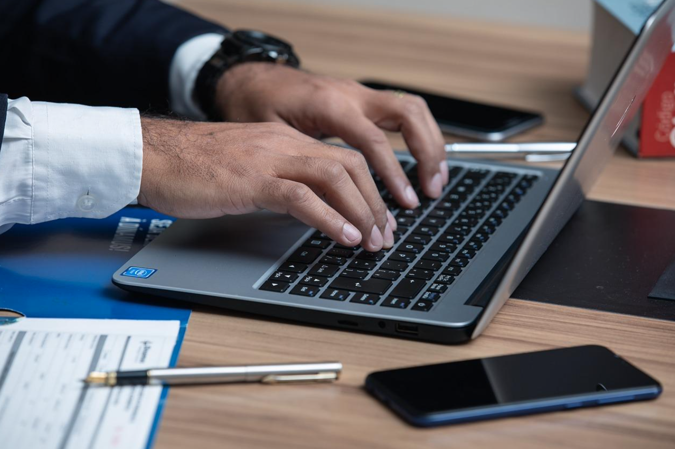 Lawyer at desk with laptop and case file; image by advogadoaguilar, via Pixabay.com.