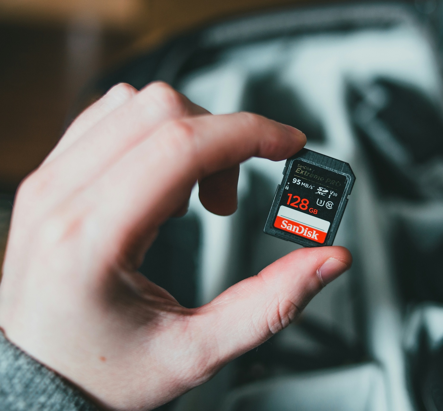 Man holding microSD card; image by Erik Mclean, via Unsplash.com.