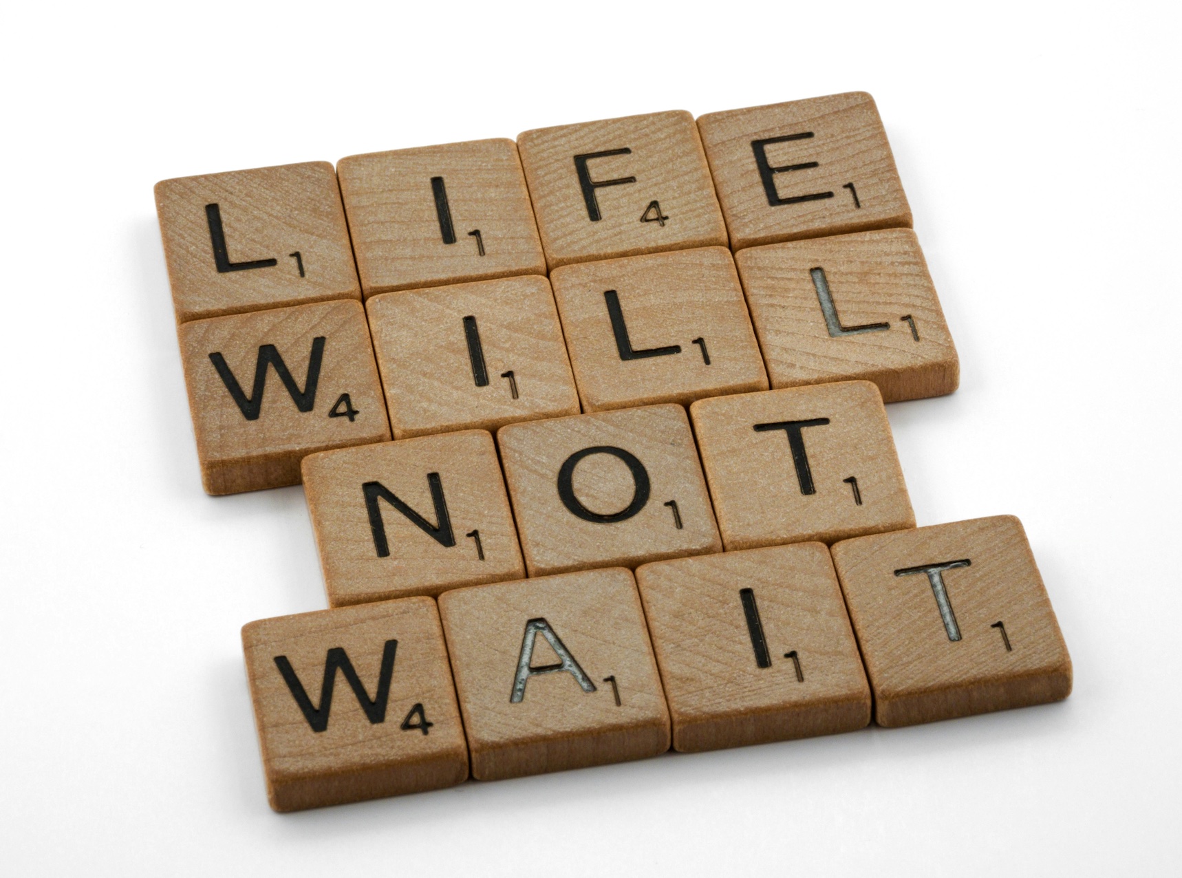 Scrabble tiles spelling out Life will not wait. Image by Brett Jordan, via Unsplash.com.